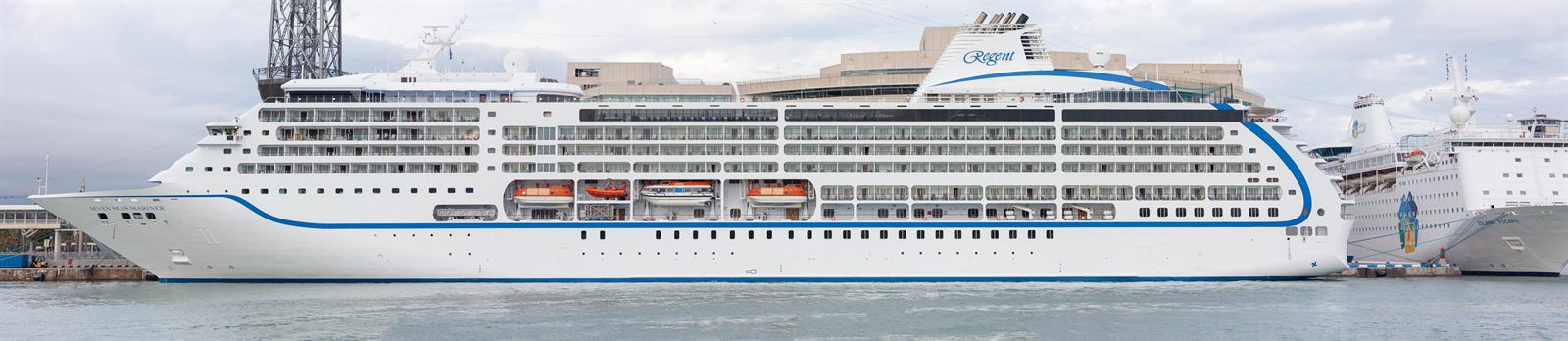 All-suite cruise ship moored alongside a quay in the sun